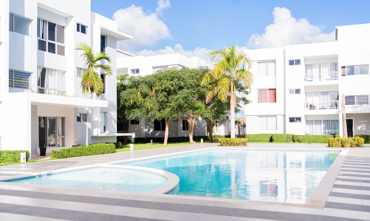 Bright modern apartment complex featuring an inviting outdoor pool area surrounded by lush greenery.