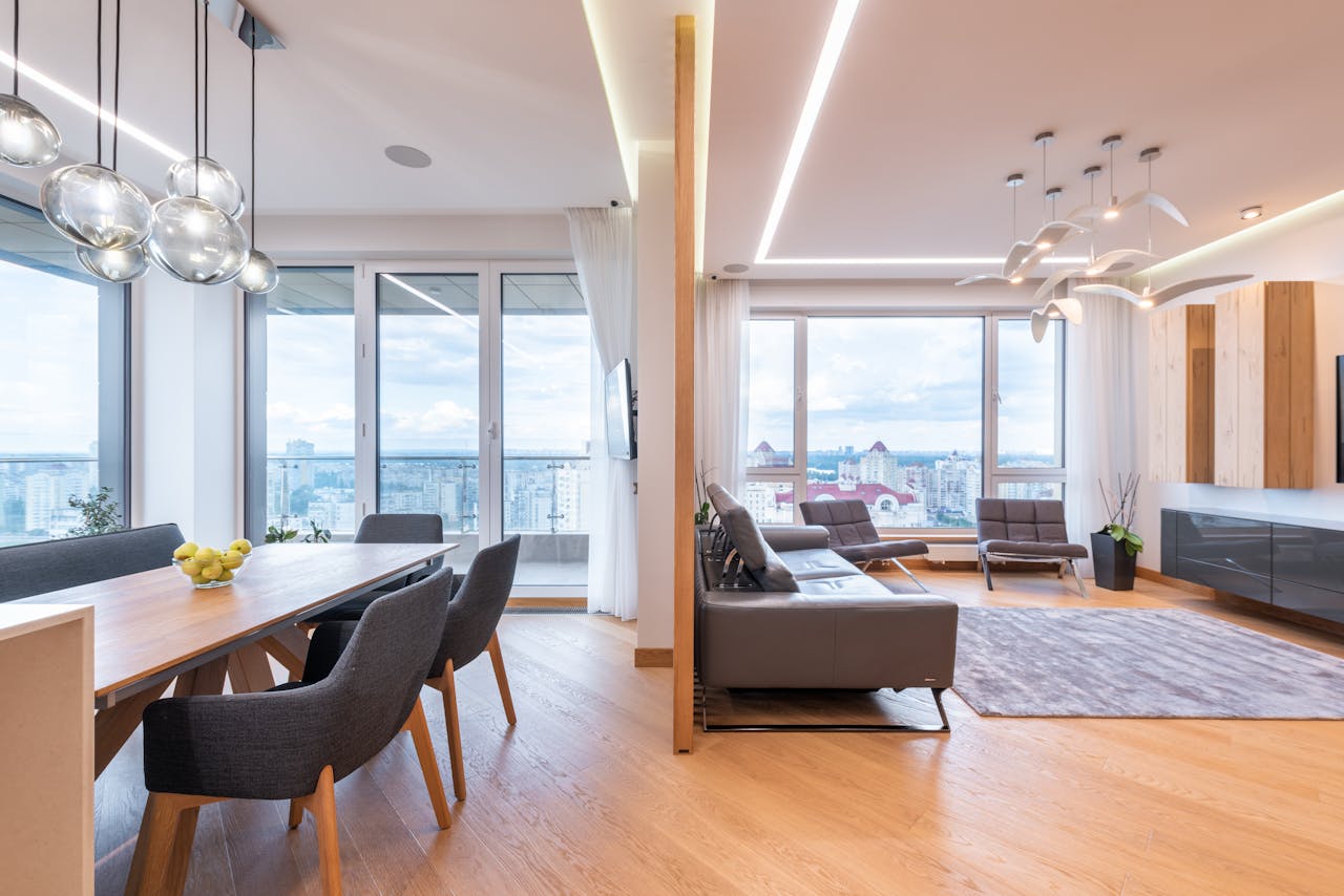 Interior of modern large flat with table and chairs near windows in daytime