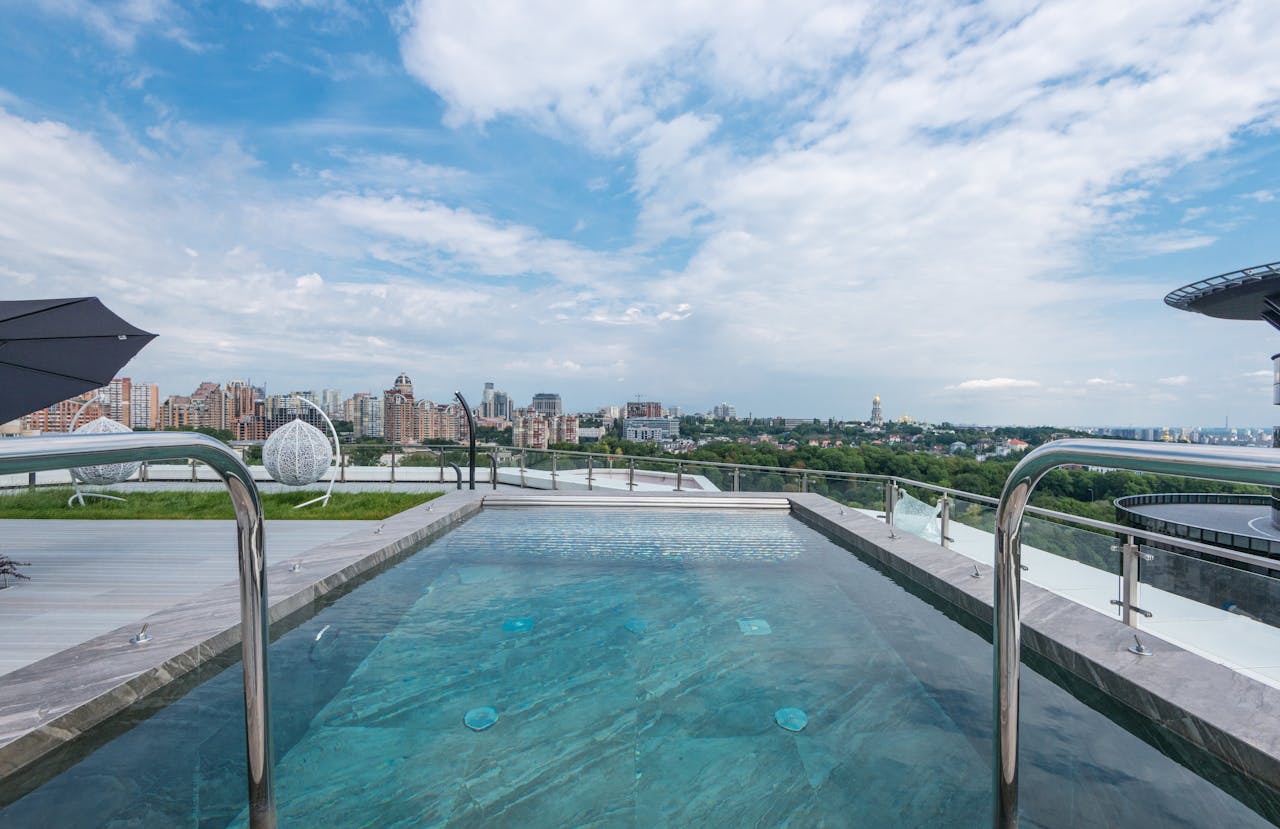 Luxurious rooftop pool with cityscape backdrop, perfect blend of nature and architecture.